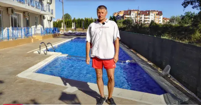Мужчина на фоне бассейна и комплекса
